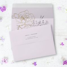 two pink envelopes with gold foil flowers on the front and back, sitting next to each other