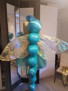 there is a sculpture made out of balloons and plastic wrap around the wings on top of it