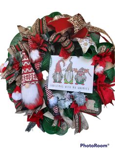 a christmas wreath with gnomes and santa hats on it's front door hanger