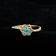 Product Details The Perfect Combination of London Blue Topaz and Diamond in this Rose Flower Ring is mesmerizing. The Round Natural London Blue Topaz is set in the Centre of Gold Petals of a Rose Flower in the curved shank. Get this Floral Inspired Engagement Ring for your Blooming Lady Love, this Blue Topaz and Diamond Engagement Ring is a stunning piece of jewelry, which she will cherish her whole life. Product Information SKU SHP-RINGS0821183068 Width 5.4 mm Height 8 mm Weight 2.10 gm (Approximate) LONDON BLUE TOPAZ INFORMATION No.of Stones 1 Pieces Total Weight 0.60 Carat (Approximate) Dimension(approx) Round-5X5 mm-1 Pcs Color Blue Cut Brilliant Shape Round Setting Type Prong-Setting Quality Grade AAA DIAMOND INFORMATION No.of Stones 18 Pieces Total Weight 0.22 Carat (Approximate) Dim Blue Flower-shaped Diamond Jewelry, Blue Gemstone Flower Ring, Rose Flower Ring, Flower Engagement, Flower Engagement Ring, 18k Yellow Gold Ring, Stone Gold, Diamond Flower, London Blue Topaz