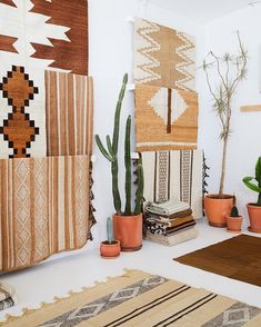 a living room filled with lots of plants and rugs on the floor next to each other