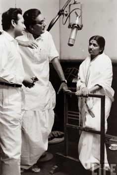 black and white photograph of three men in front of a microphone