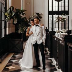 a bride and groom are standing together in the hallway