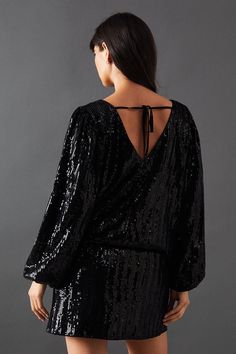 the back of a woman's black sequinned dress