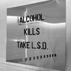 a sign that says alcohol kills take l s d on the side of a wall