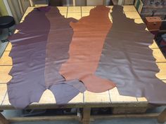 three different colored pieces of paper sitting on top of a wooden table in a room