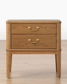 a wooden nightstand with two drawers on top of the legs and one drawer in the middle