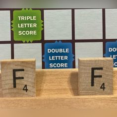 three scrabble tiles with letters spelling the word f4 and 4 for each letter