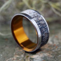 a wedding ring made out of antler wood and gold inlays on the outside