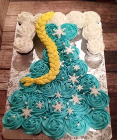 there is a cake made to look like a princess dress with blue frosting and yellow icing