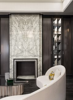 an elegant living room with white furniture and marble fireplace mantel in the center, surrounded by dark wood paneling