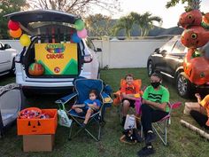 some people sitting in lawn chairs with halloween decorations