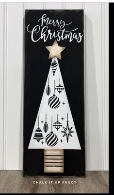 a black and white christmas card with a wooden tree on the front, merry christmas