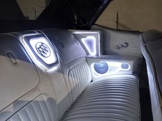 the interior of a car with an illuminated emblem on it's dash board and seats