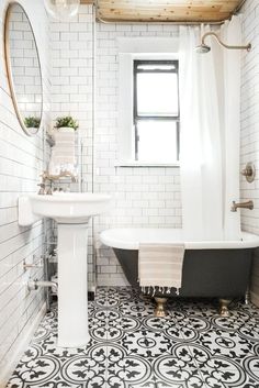 a bath room with a sink and a bath tub next to a window on the wall