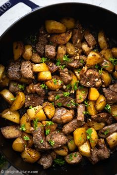 steak and potatoes in a skillet with parsley