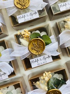 wedding favors are arranged in small boxes with ribbons and flowers on them for guests to sign