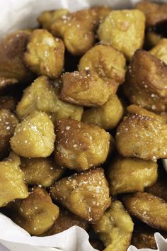 a close up of some fried food in a paper bag with sugar sprinkled on top