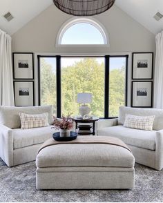 a living room with two couches and a coffee table in front of a large window