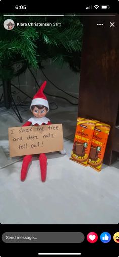 an elf is holding a sign next to some candy