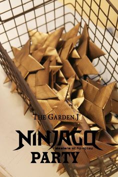 a metal basket filled with wooden stars on top of a white table next to a sign that reads the garden ninja party