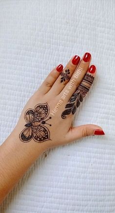 a woman's hand with henna tattoos on it