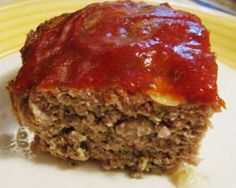 a piece of meatloaf sitting on top of a white plate with red sauce