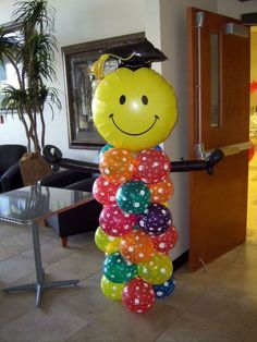 a balloon sculpture in the shape of a smiley face wearing a graduation cap and gown