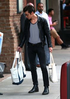 a man walking down the street carrying two bags