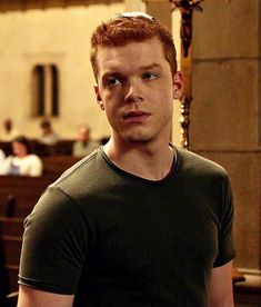 a man standing in front of a church pews with his hands on his hips