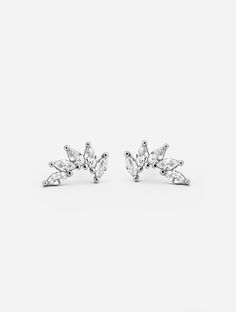 Sparkling Marquise Stud Earrings  Add a little diamond-like sparkle to your ears with these elegant wing-shaped stud earrings. Featuring a row of five marquise-cut Cubic Zirconia stones. 𝗣𝗥𝗢𝗗𝗨𝗖𝗧 𝗗𝗘𝗧𝗔𝗜𝗟𝗦 Size: Approx. 1cm x 0.5cm  Colour: Silver  Metal: 18 White Carat Gold Plated 925 Sterling Silver Earring Style: Stud Earrings Shape: Marquise Crown  Stone: Cubic Zirconia 𝗚𝗢𝗢𝗗 𝗧𝗢 𝗞𝗡𝗢𝗪 Each one of our stud earrings is carefully handcrafted from precious metals. We work with Luxury Silver Marquise Cut Earrings, Silver Marquise Cut Cluster Earrings, Luxury Marquise Cut Sterling Silver Earrings, Luxury Silver Marquise Bridal Earrings, Sterling Silver Diamond Earrings, Brilliant Marquise Cut, Marquise Jewelry, Wedding Studs, Name Earrings, White Jewelry Box