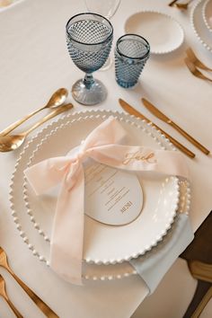 a table set with plates, silverware and napkins