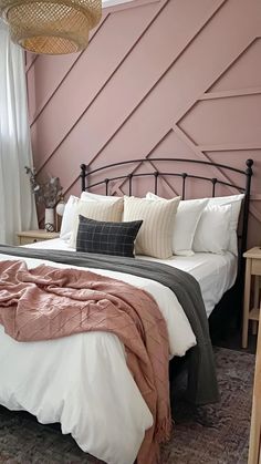 a bedroom with pink walls and white bedding