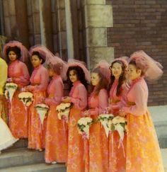 a group of women standing next to each other in front of a building with veils on