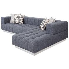 a large gray couch sitting on top of a white floor next to pillows and pillow cases