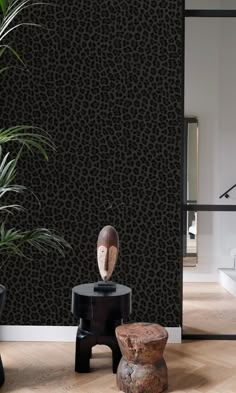 an animal print wallpaper in a living room with two stools and a potted plant