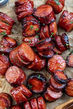 cooked sausages on parchment paper next to a wooden spoon