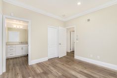 an empty room with hard wood floors and white doors on either side of the door