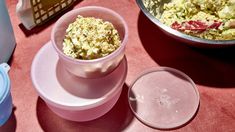 there are two containers with food in them on the table next to another container that is empty