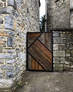 a wooden gate on the side of a stone building