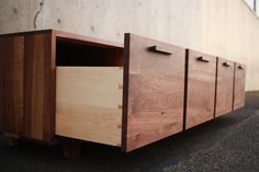 a wooden cabinet sitting on the side of a building