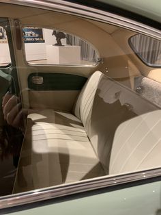 the interior of an old car with white leather seats