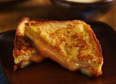 a grilled cheese sandwich on a black plate