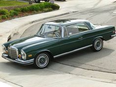 a green car is parked on the street