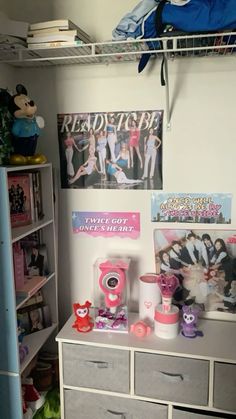 there is a closet with many items on the shelves and in front of it are posters