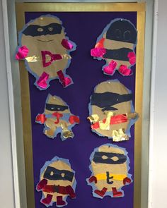 the door is decorated with paper cut out of superheros and pink bows on them