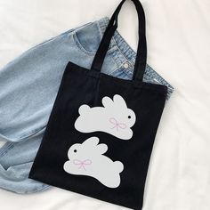 "Coming in 2 different colors, natural and black, with a super cute and simple bunny design, this canvas tote bag is a perfect complement to your daily outfit ୨୧🐇 ♡ More of Coquette Aesthetic: https://www.etsy.com/shop/RainieshopDesign?ref=seller-platform-mcnav§ion_id=1 ✮ ⋆ ˚｡  PRODUCT DETAILS  ⋆｡o✩ ✧ 100% cotton canvas ✧  Heavy fabric (12 oz/yd² (406.9 g/m ✧ Sewn-in label ✧ One size -15\" x 16\" (handles are 20\" long)   PRODUCT DETAILS  ▸ Hand wash ▸ Tumble dry: low heat ▸ Non-chlorine: bleach as needed ▸ Do not iron directly over the printed area - print may stick to the iron ▸ Do not dry clean ₊ ⊹₍ᐢᐢ₎ ♡ We truly appreciate your support and look forward to seeing your photos and reading your reviews. ♡ If you ever encounter any issues or have any questions, please reach out to us. Your Cute Everyday Bags With Bunny Design, Cute Bunny Design Bags For Everyday Use, Cute Bunny Design Bag For Everyday Use, Black Casual Reusable Bag, Casual Black Reusable Bag, Cute Black Canvas Bag For Everyday, Cute Everyday Black Canvas Bag, Casual Black Canvas Bag As Gift, Black Reusable Canvas Bag For Everyday