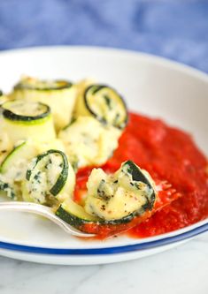 a white plate topped with zucchini and sauce