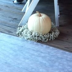 a white pumpkin sitting on top of a wooden floor