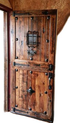 an old wooden door with metal handles and knobs on the outside side of it